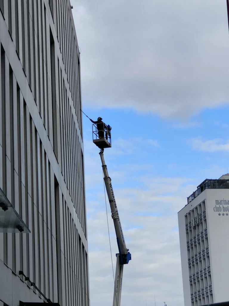 Podnośnik z operatorem przy wielokondygnacyjnym budynku
