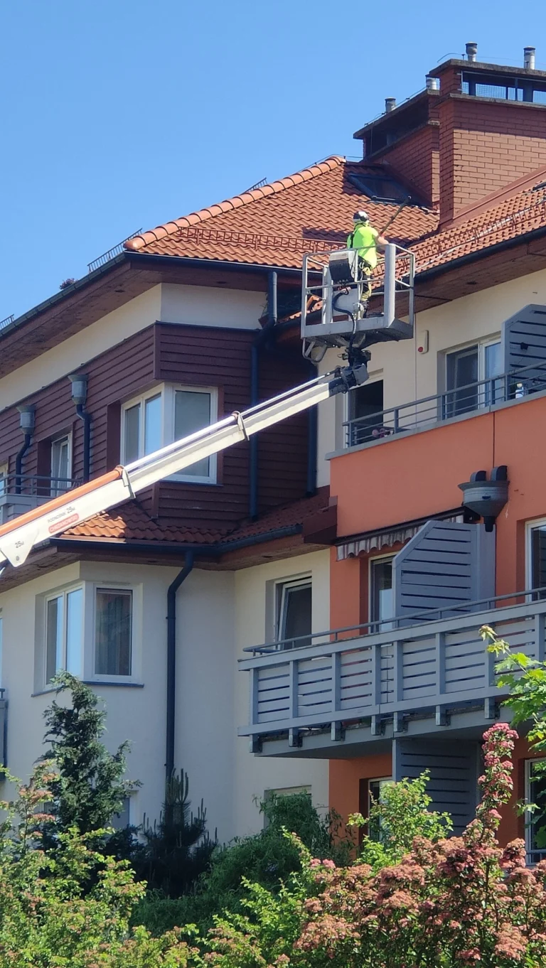 Operator w koszu przy górnej kondygnacji budynku