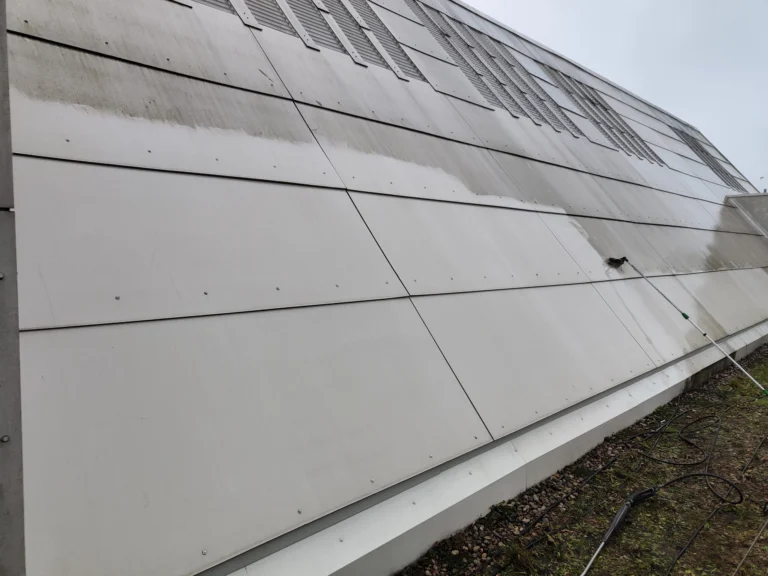 Pasowe zabrudzenia na jasnej obudowie budynku