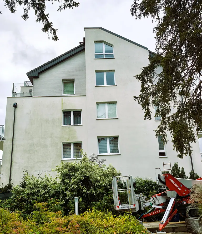 Częściowo wyczyszczona elewacja budynku w Gdyni i podnośnik AquaUp
