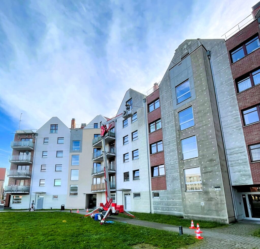Podnośnik AquaUp podczas pracy przy elewacji budynku wielorodzinnego